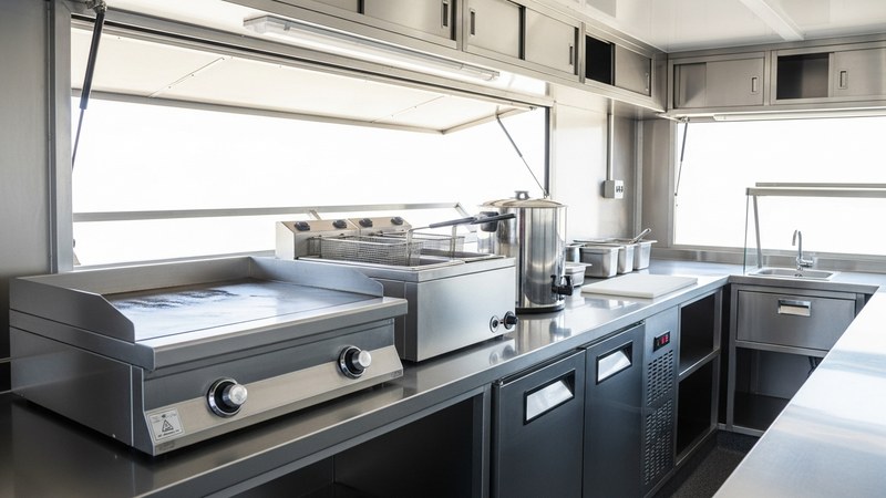 The stainless steel appliance line-up inside a well-equipped UK mobile catering trailer