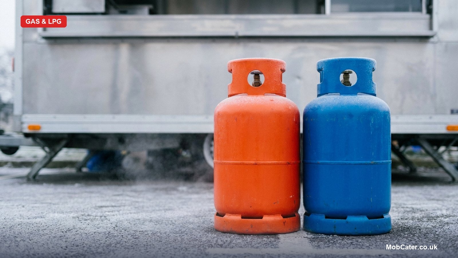 An orange propane gas bottle and a blue butane gas bottle side by side outside a UK catering trailer