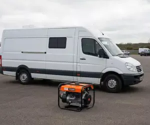 A diesel generator on the tarmac next to a small mobile catering van on a private trading pitch.