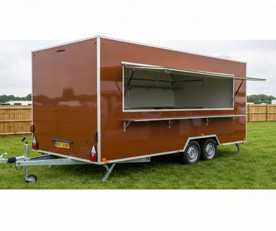 Chestnut brown twin-axle mobile catering trailer with a side serving hatch open at a UK showground