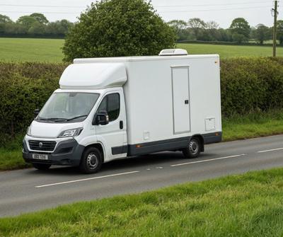 Mobile catering van driving on a UK country road between pitches