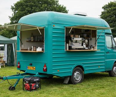 Teal converted horsebox mobile coffee unit with a portable generator at a UK country event