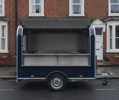 Navy blue single-axle mobile catering trailer parked as a street food pitch on a South Manchester street