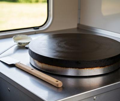 Cast iron gas crepe maker plate heating in a mobile catering trailer