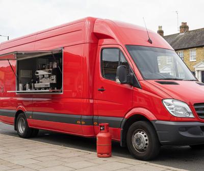 Red coffee and sandwich van with a propane gas cylinder on a UK high street