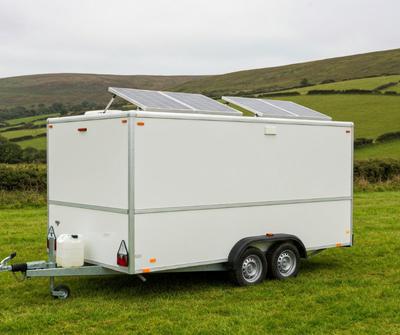 White catering trailer with roof solar panels in the Welsh countryside