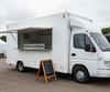 White mobile burger van with its serving hatch open at a UK outdoor event
