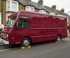 Burgundy food truck parked on a sloping UK street with wheel chocks