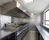 Stainless steel extraction canopy mounted inside a catering unit above the fryers and griddle