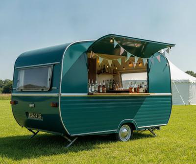 Teal converted vintage caravan mobile bar at a UK summer events field