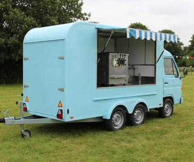 Pastel blue soft-serve ice cream van serving from a side hatch at a British summer fete